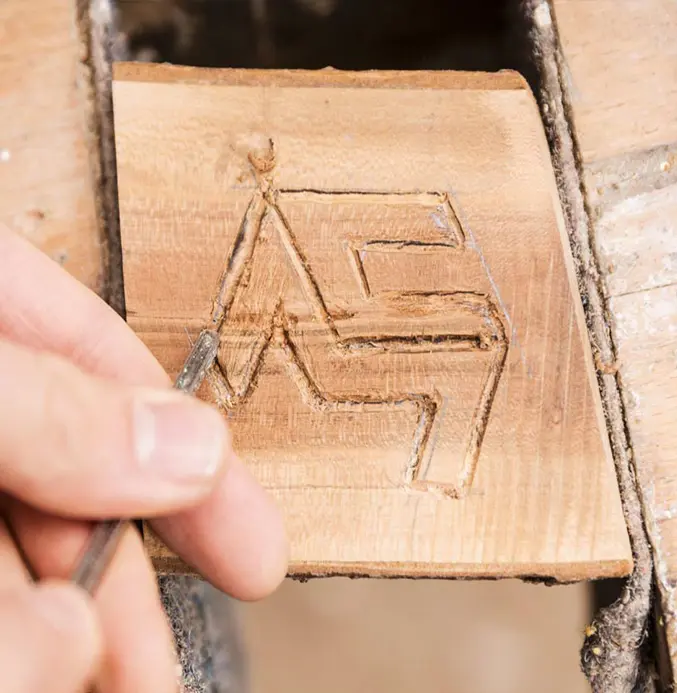 Das codemanufaktur Logo in Holz geschnitzt.